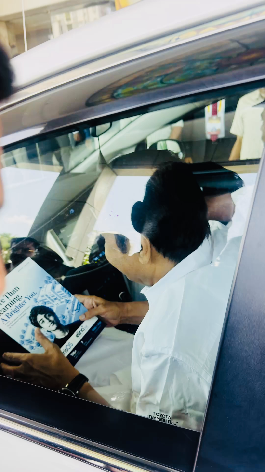 Attendee reading the Lyrabyte brochure inside a vehicle